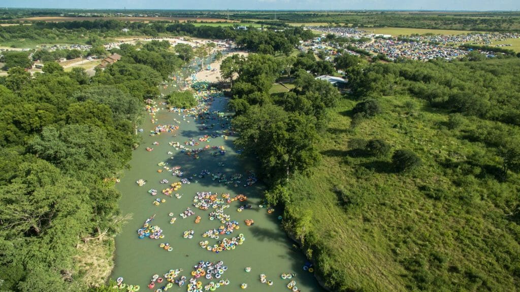 Prise de vue par drone de centaines de rafters flottant sur une rivière.