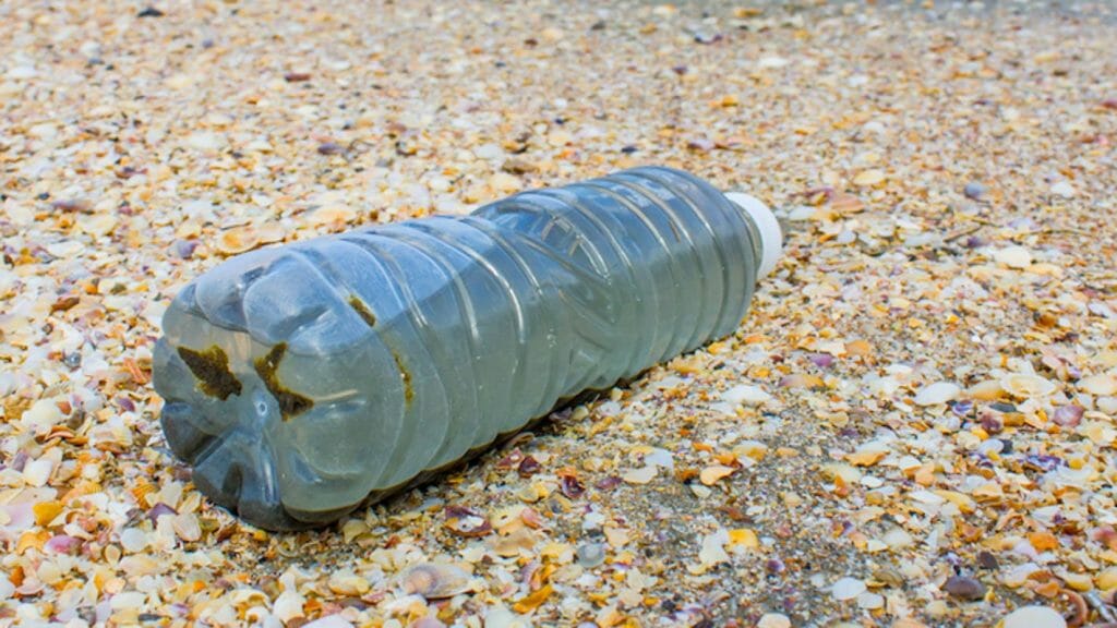Bouteille d'eau en plastique posée sur le sable