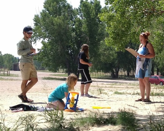 Voluntarios tomando notas en un campo de arena