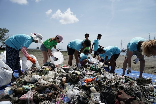 Volunteers clean up trash on the beach.